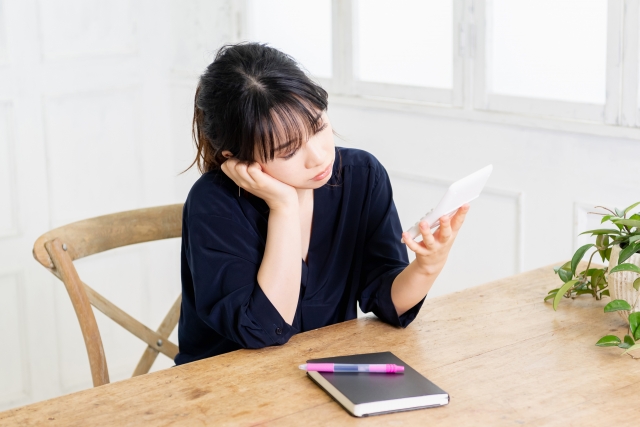 電卓を持ち悩む女性